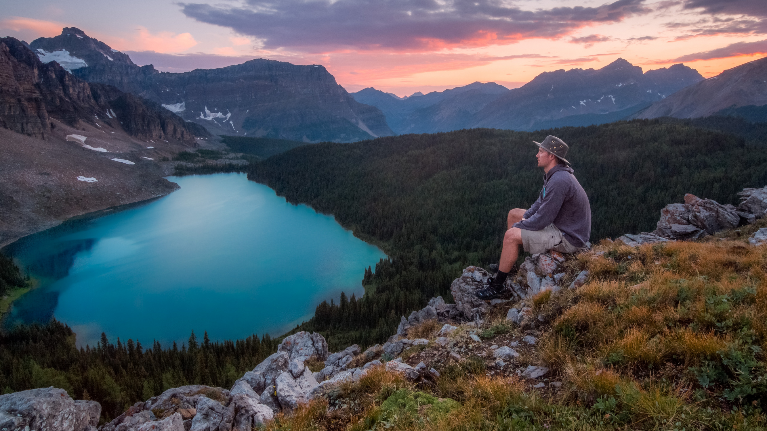 Hiker looking over a lake from a tall hill